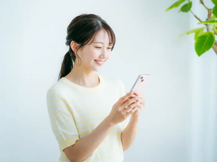 スマートフォンのLINEから整骨院の予約をする女性